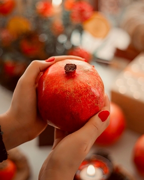 手持红色新鲜石榴摄影图片